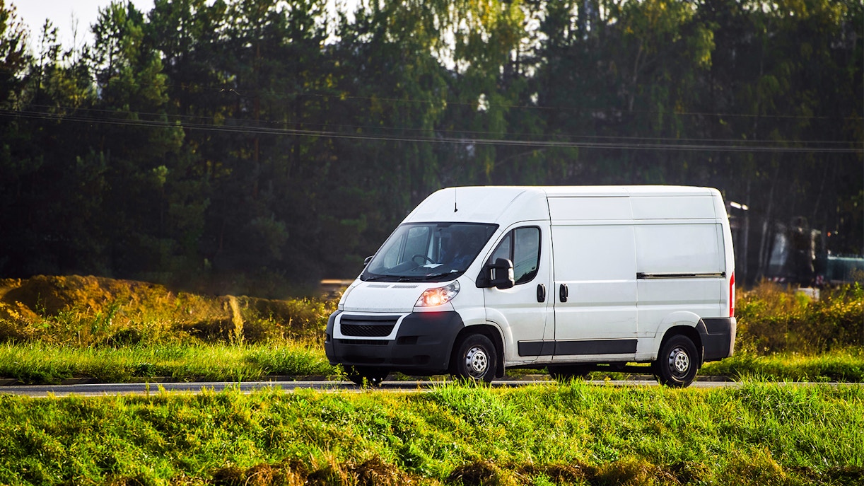 Mini bus parked near scenic mountain road in Switzerland.