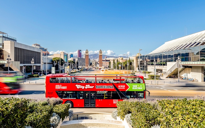 Red double-decker bus on Barcelona hop-on hop-off tour near Plaça d'Espanya.