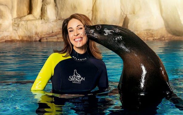 Sea lion kisses woman on cheek at Aquaventure Waterpark, Dubai.