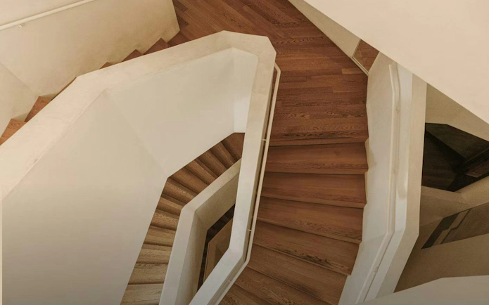 Casa Vicens basement floor staircase with wooden steps and white railings.