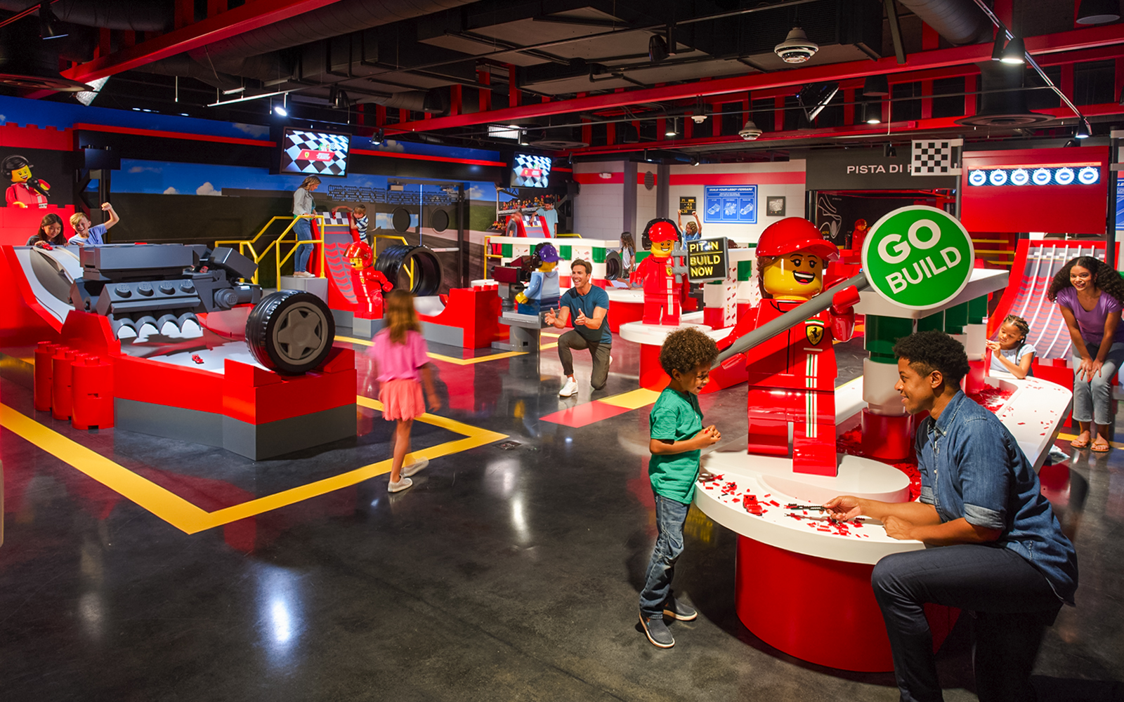 Children and adults building LEGO Ferrari models at Legoland Florida's Build and Race attraction.