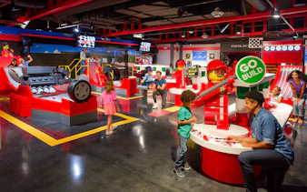 Children and adults building LEGO Ferrari models at Legoland Florida's Build and Race attraction.