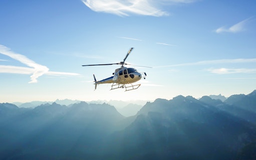 Helicopter flying over mountains near Swiss capital city.