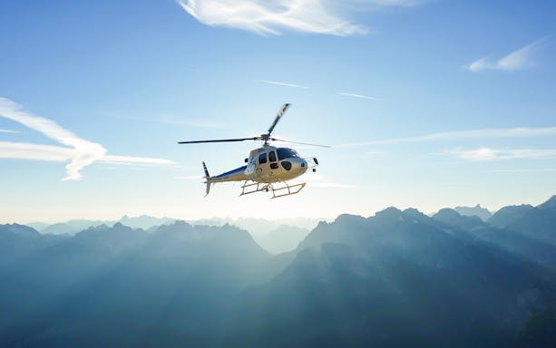 Helicopter flying over mountains near Swiss capital city.