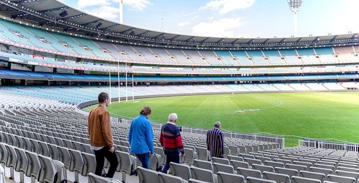 Visitors walking through Melbourne Cricket Ground on a guided sports tour.