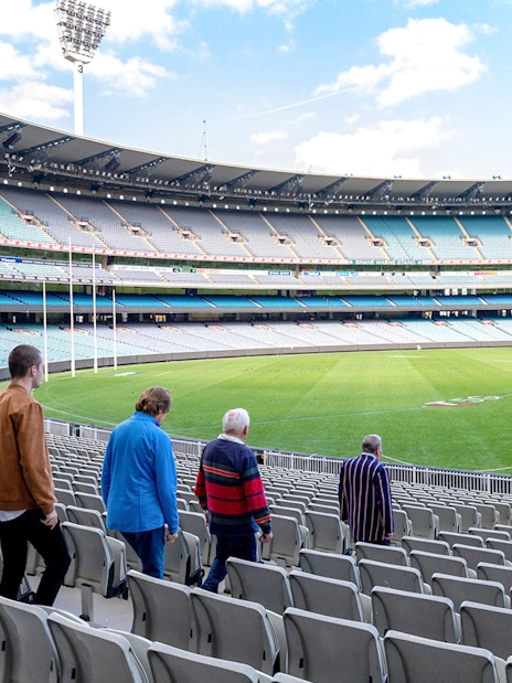 Visitors walking through Melbourne Cricket Ground on a guided sports tour.