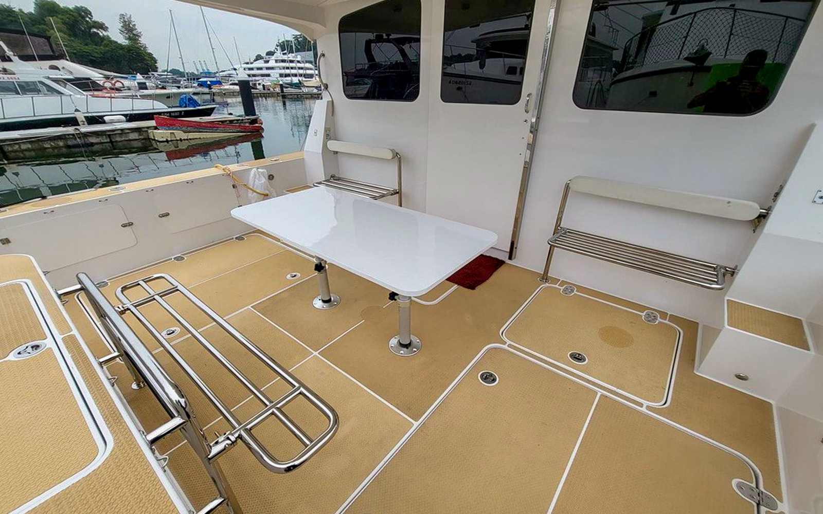 Private yacht SunRise deck with seating and table at marina.
