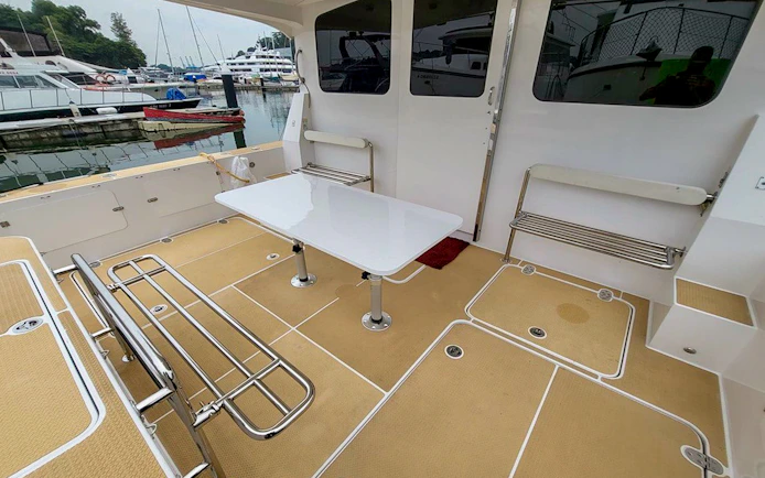 Private yacht SunRise deck with seating and table at marina.