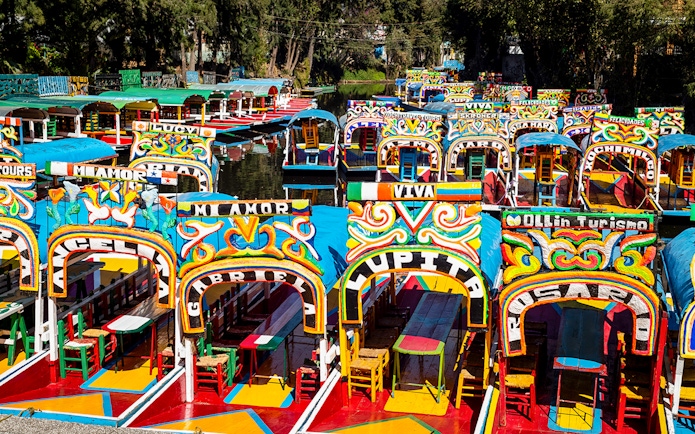 Colorful trajineras lined up in Xochimilco, Mexico City canal.
