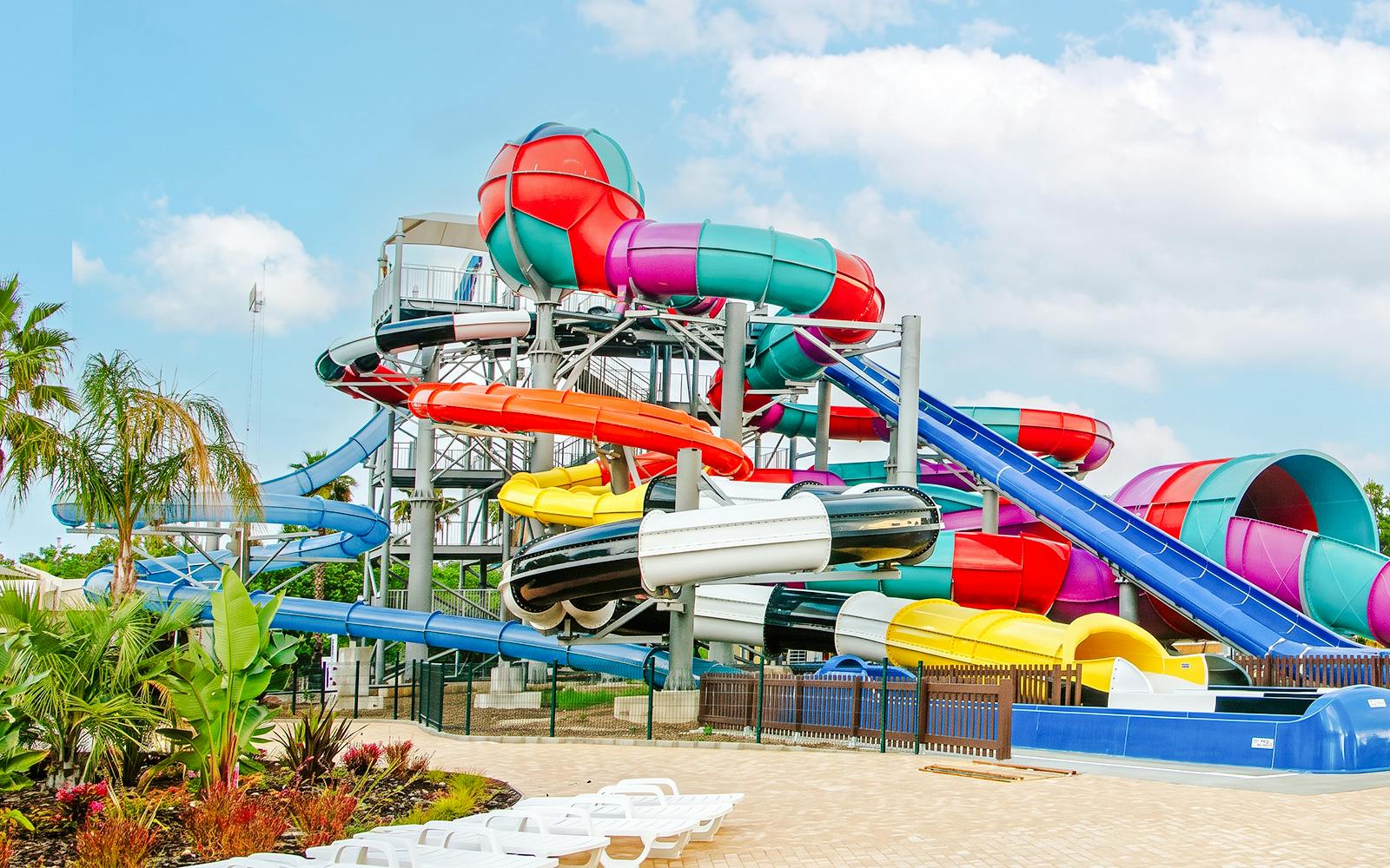 Colorful water slides at Aquasplash Antibes, France, with tropical plants nearby.
