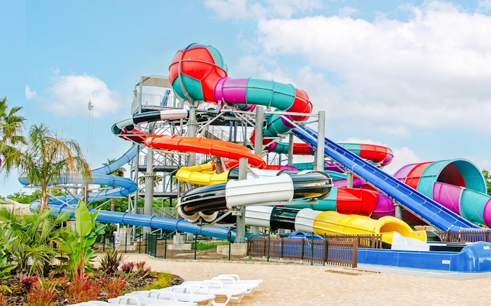 Colorful water slides at Aquasplash Antibes, France, with tropical plants nearby.