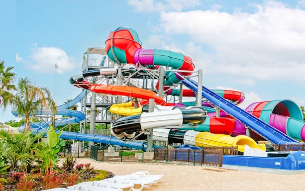 Colorful water slides at Aquasplash Antibes, France, with tropical plants nearby.