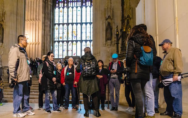 Group of tourists listening to a guide inside the Houses of Parliament, London.
