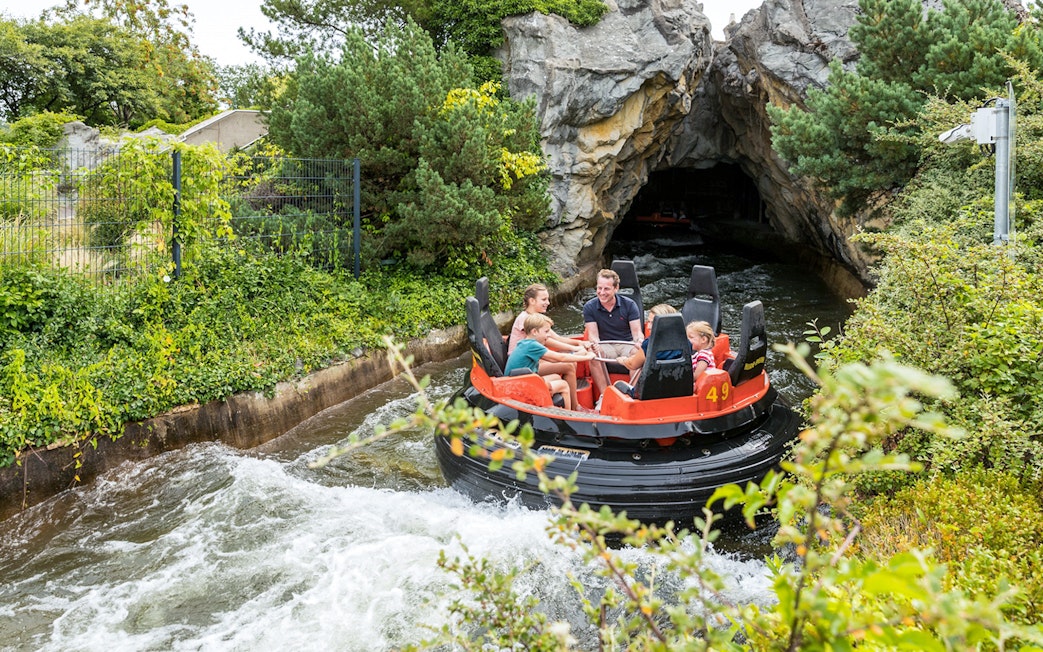 Raft ride at Heide Park with visitors entering a rocky tunnel.