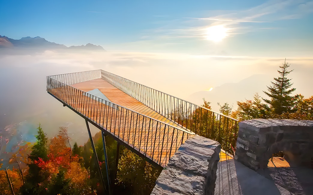 Harder Kulm viewing platform overlooking misty mountains and forest in Interlaken, Switzerland.