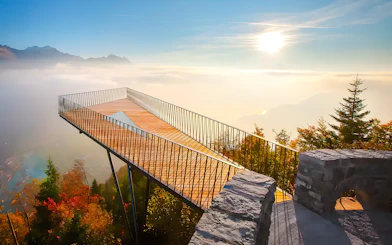 Harder Kulm viewing platform overlooking misty mountains and forest in Interlaken, Switzerland.