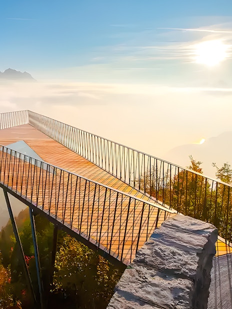 Harder Kulm viewing platform overlooking misty mountains and forest in Interlaken, Switzerland.