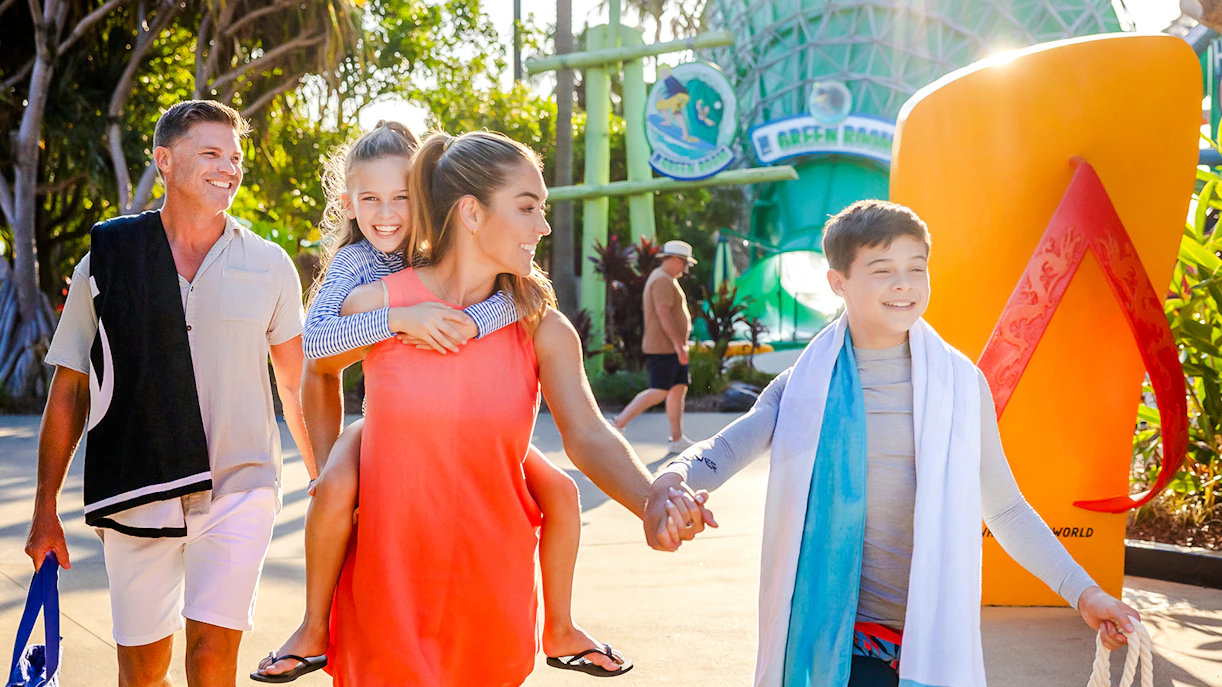 Family enjoying a day at Whitewater World, Gold Coast, with children smiling and holding hands.