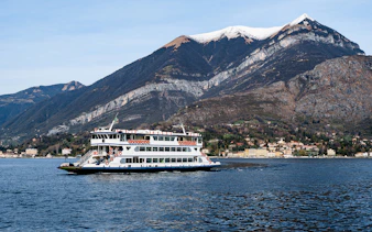 Cruise boat on Lake Como with mountains in the background during Lugano and Bellagio tour.