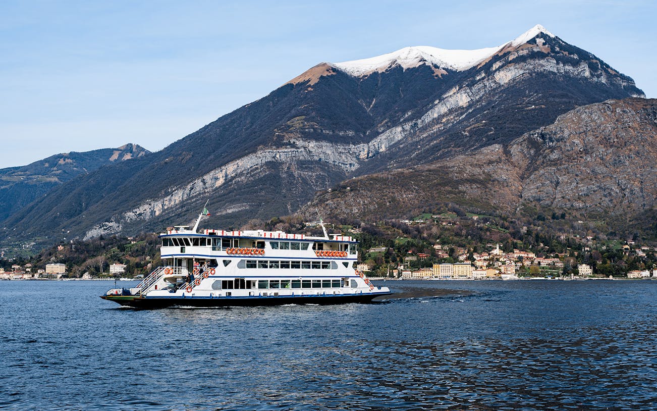 Cruise boat on Lake Como with mountains in the background during Lugano and Bellagio tour.