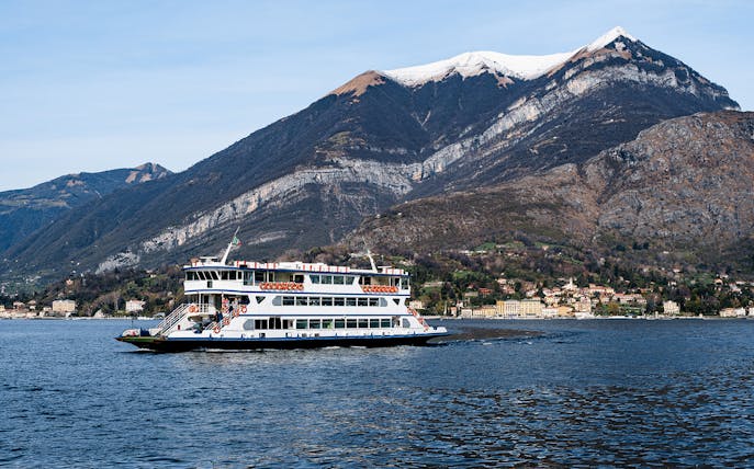 Cruise boat on Lake Como with mountains in the background during Lugano and Bellagio tour.