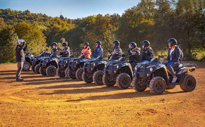 Group on quad bikes receiving instructions during Algarve full-day tour.