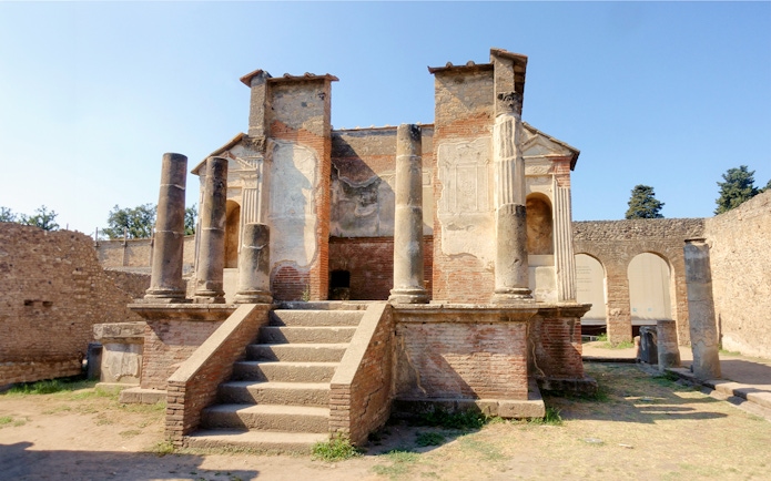 Ancient ruins of a temple in Pompeii with stone columns and steps.