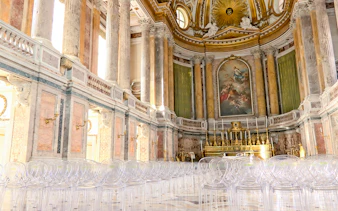 Royal Palace interior with ornate columns and grand altar, featuring clear seating for visitors.
