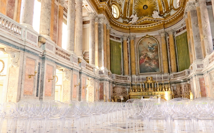 Royal Palace interior with ornate columns and grand altar, featuring clear seating for visitors.