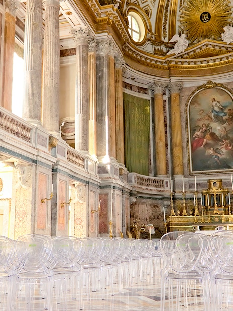 Royal Palace interior with ornate columns and grand altar, featuring clear seating for visitors.