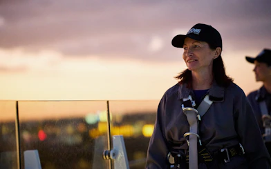 Person enjoying rooftop view during Vertigo by Twilight experience.