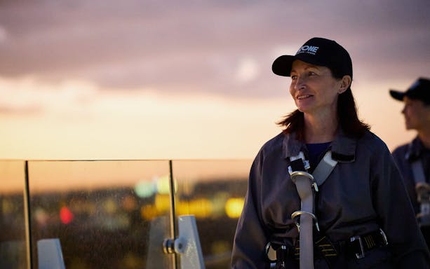 Person enjoying rooftop view during Vertigo by Twilight experience.