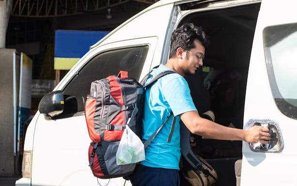 Traveler boarding a van for one-way transfer from Katowice Airport to Krakow.