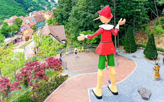 Large Pinocchio statue overlooking colorful houses in Italian Village, South Korea.
