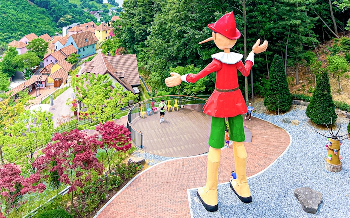 Large Pinocchio statue overlooking colorful houses in Italian Village, South Korea.