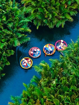 Aerial view of basket boats navigating lush greenery in Hoi An, Vietnam river.