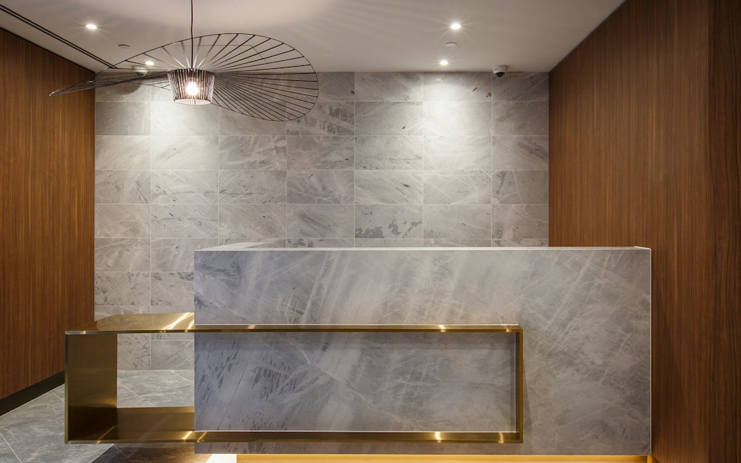 Reception desk at Plaza Premium Lounge with modern lighting and marble accents.