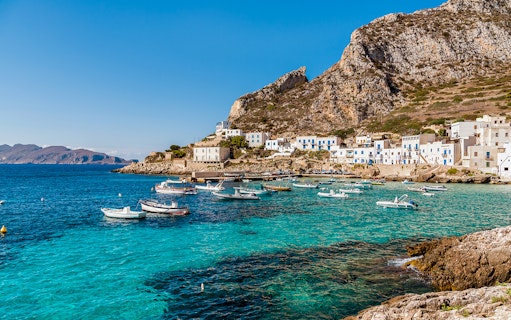 Boats anchored near the rocky coastline of Egadi Islands, viewed from Marsala.