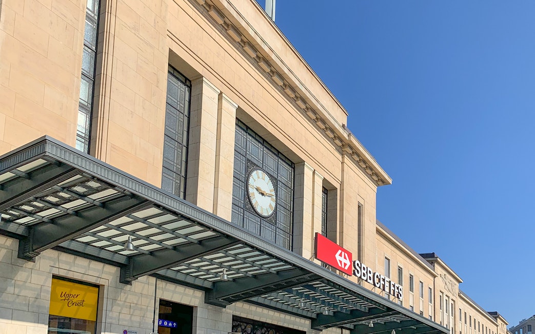 Geneva Train Station entrance with clock and SBB CFF FFS sign.