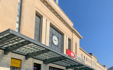 Geneva Train Station entrance with clock and SBB CFF FFS sign.