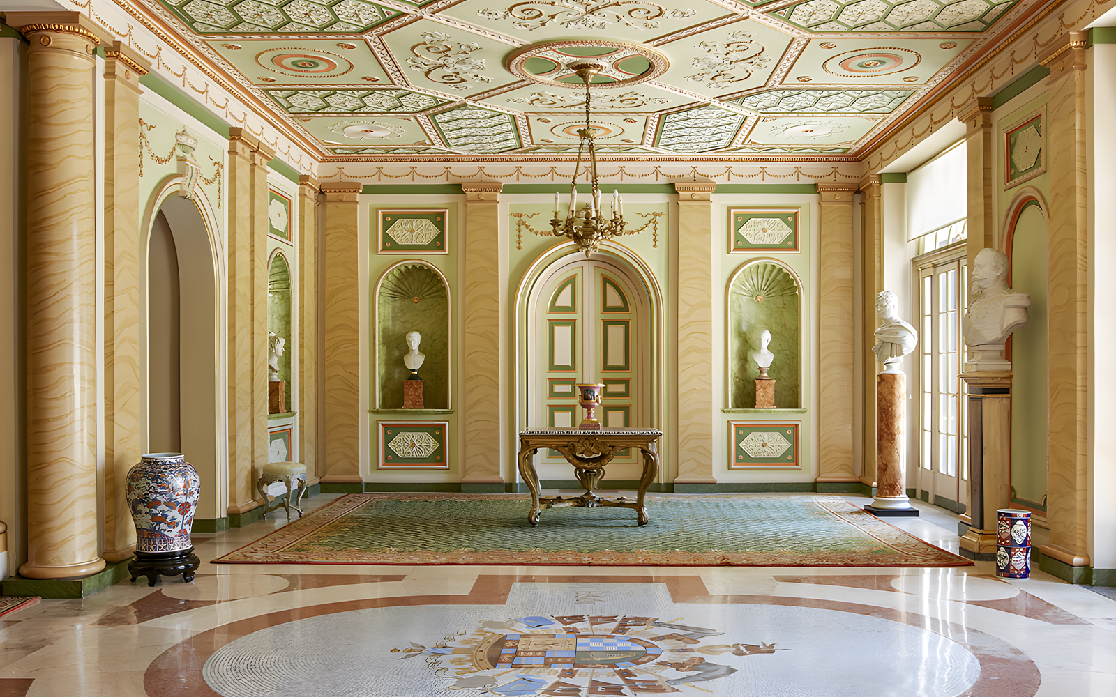 Interior of Liria Palace in Madrid featuring ornate ceiling, busts, and decorative columns.