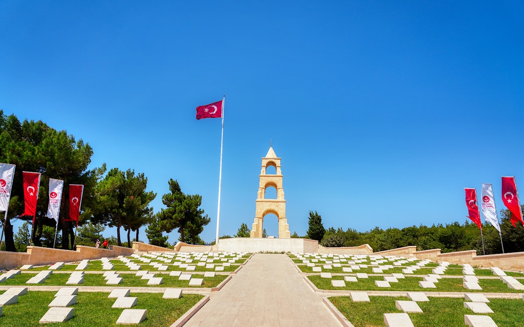 Gallipoli Peninsula memorial site with Turkish flags and Lone Pine Cemetery headstones.