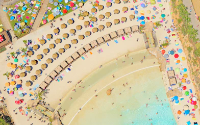 Aerial view of Zoomarine Algarve beach with sunbathers, umbrellas, and clear water.