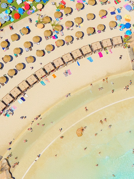 Aerial view of Zoomarine Algarve beach with sunbathers, umbrellas, and clear water.