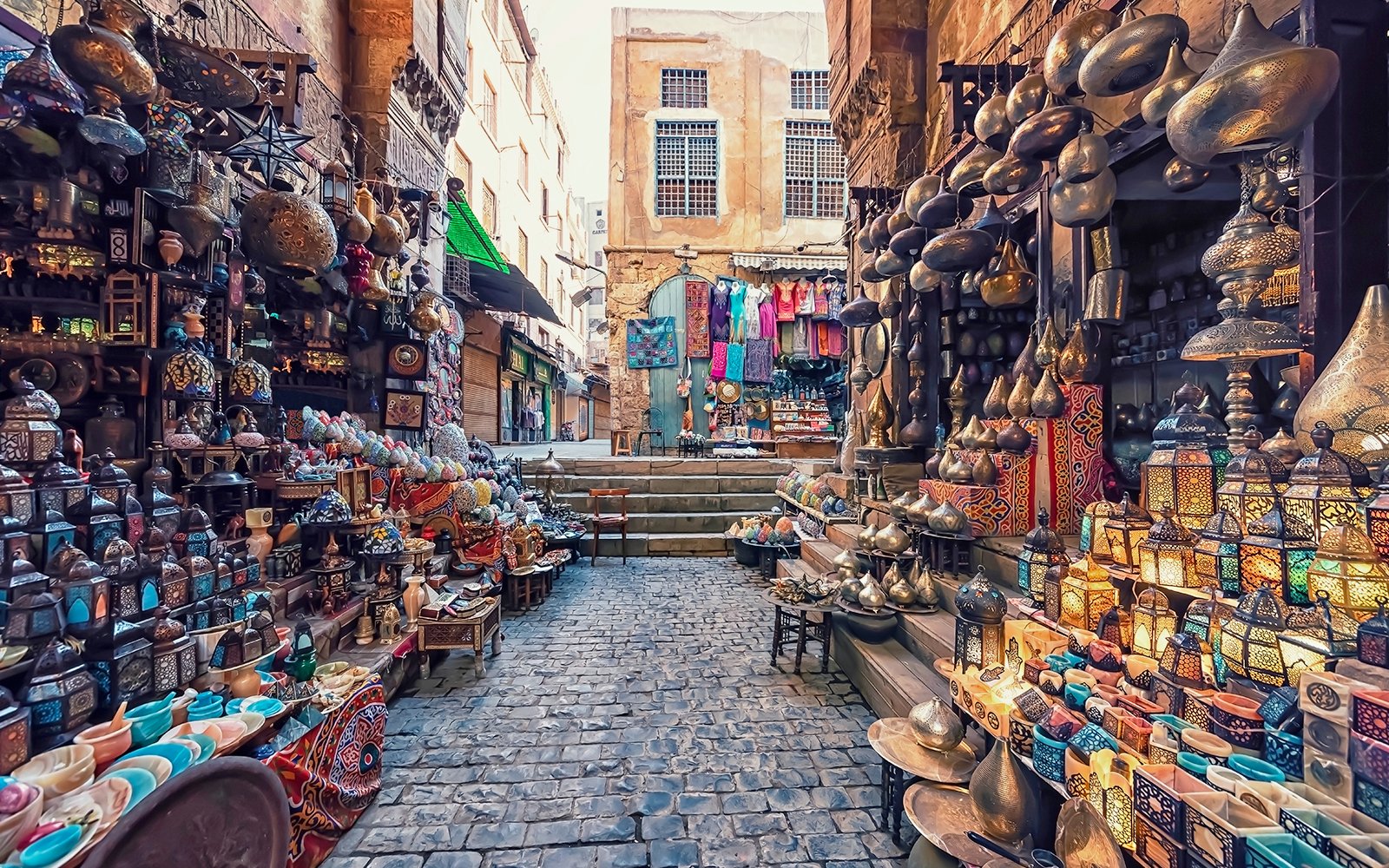 Market stalls with colorful lanterns and pottery at Khan El Khalili Bazaar, Cairo.