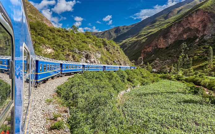 Train traveling through lush mountains near Cusco, Peru.