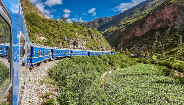 Train traveling through lush mountains near Cusco, Peru.