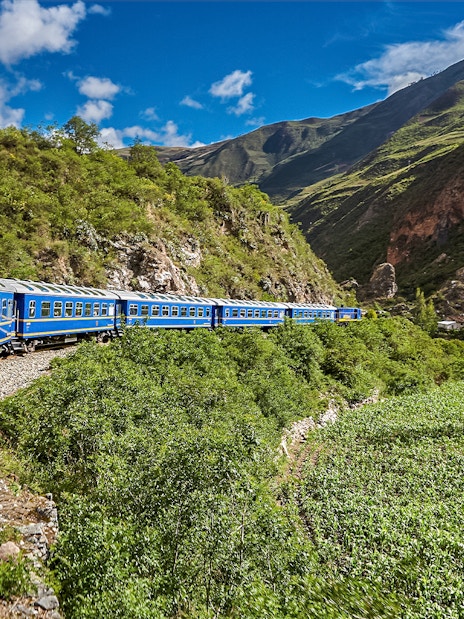 Train traveling through lush mountains near Cusco, Peru.