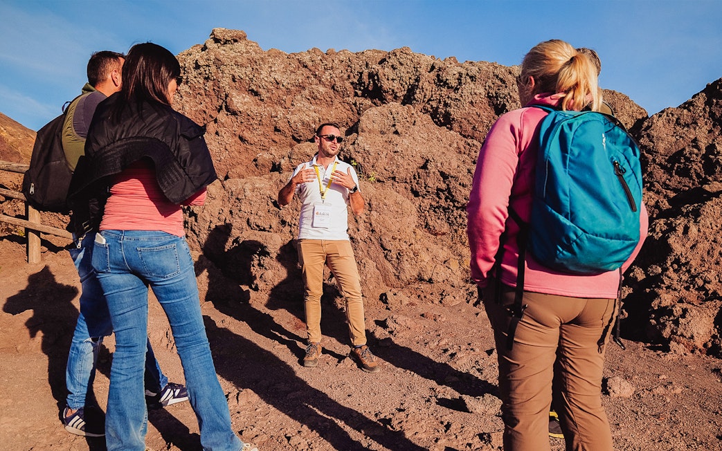 Tour guide explaining volcanic features to a group at Mt. Vesuvius, Italy.