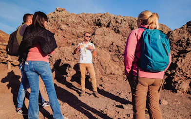 Tour guide explaining volcanic features to a group at Mt. Vesuvius, Italy.